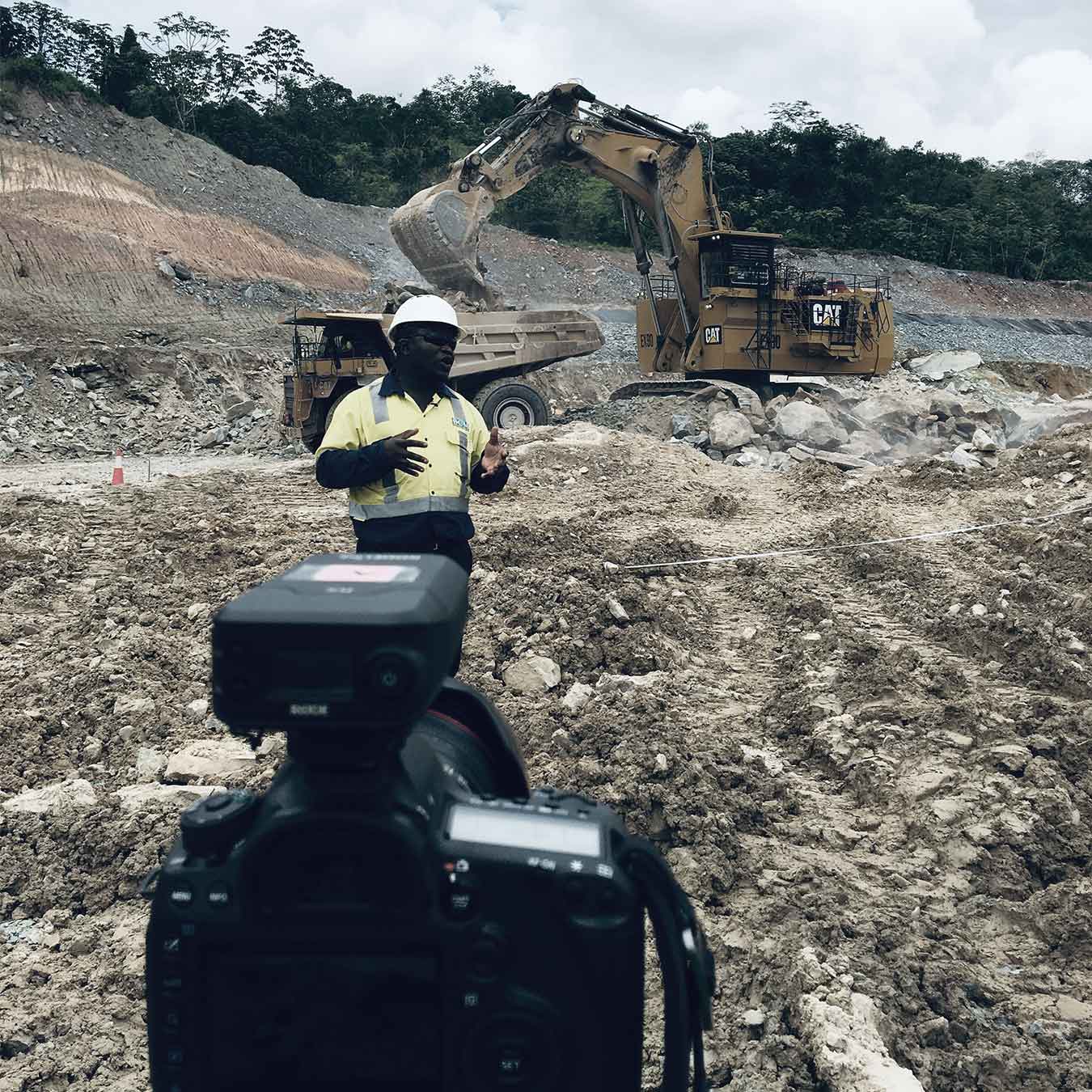 Industrial photography shoot on mining site with site worker and heavy machinery